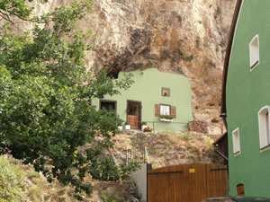 Höhlenwohnung in Kallmünz. Eine höle die mit einer Mauer verschlossen ist.